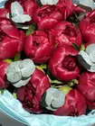 Букет из 15 бордовых пионов Red Charm с эвкалиптом заказать в Томске